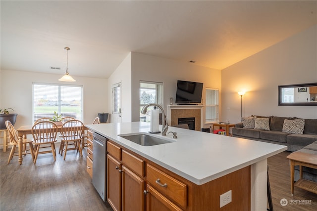 kitchen with sink, a center island with sink, hardwood / wood-style floors, hanging light fixtures, and lofted ceiling