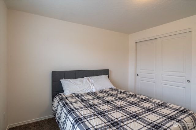 bedroom featuring dark colored carpet and a closet