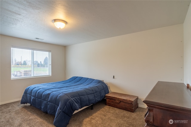 bedroom with light carpet and a textured ceiling