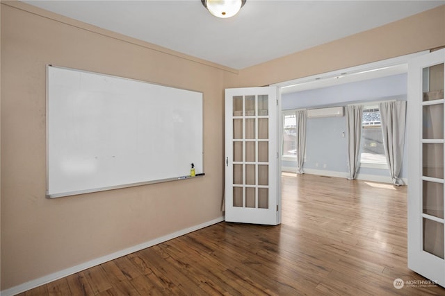 15525 NE Caples Rd, Brush Prairie, WA 98606 - empty room with a wall mounted AC, baseboards, wood finished floors, and french doors