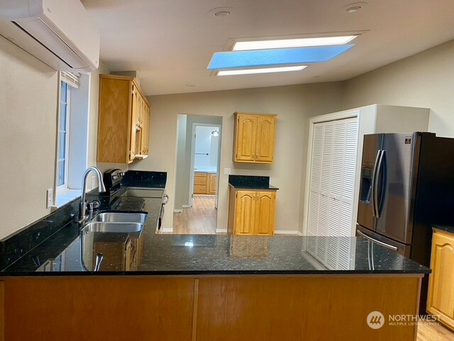 2722 S 371st St, Federal Way, WA 98003 - kitchen featuring kitchen peninsula, lofted ceiling with skylight, stainless steel appliances, and light hardwood / wood-style floors