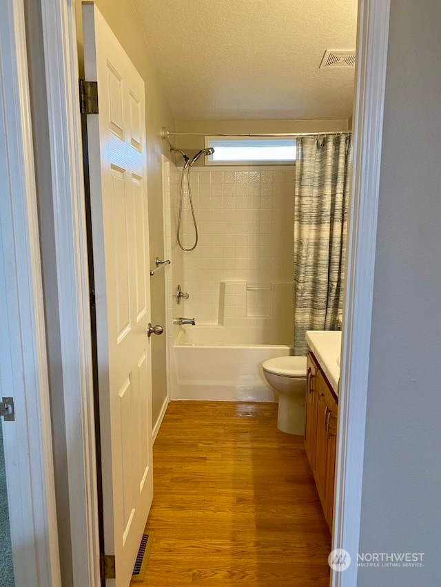 2722 S 371st St, Federal Way, WA 98003 - full bathroom featuring hardwood / wood-style floors, vanity, toilet, shower / bath combo with shower curtain, and a textured ceiling