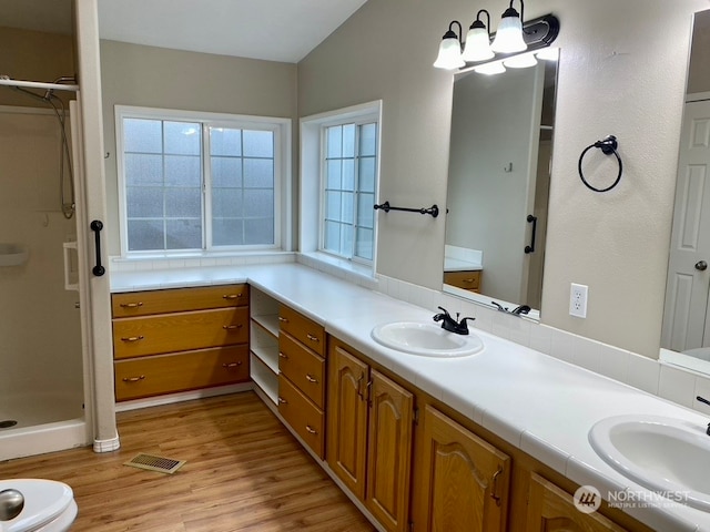 2722 S 371st St, Federal Way, WA 98003 - bathroom with walk in shower, vanity, vaulted ceiling, an inviting chandelier, and hardwood / wood-style floors