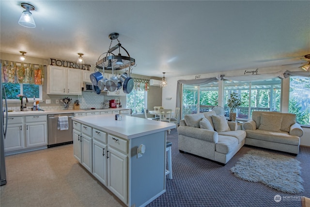 kitchen with sink, ceiling fan, appliances with stainless steel finishes, a center island, and white cabinets