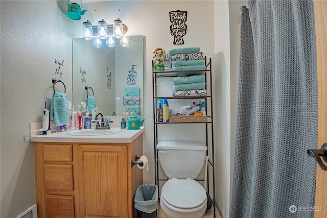 bathroom featuring vanity, curtained shower, and toilet