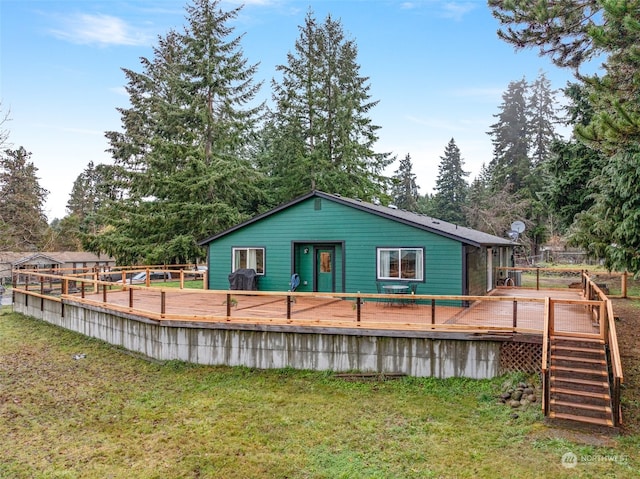 rear view of house with a lawn and a deck