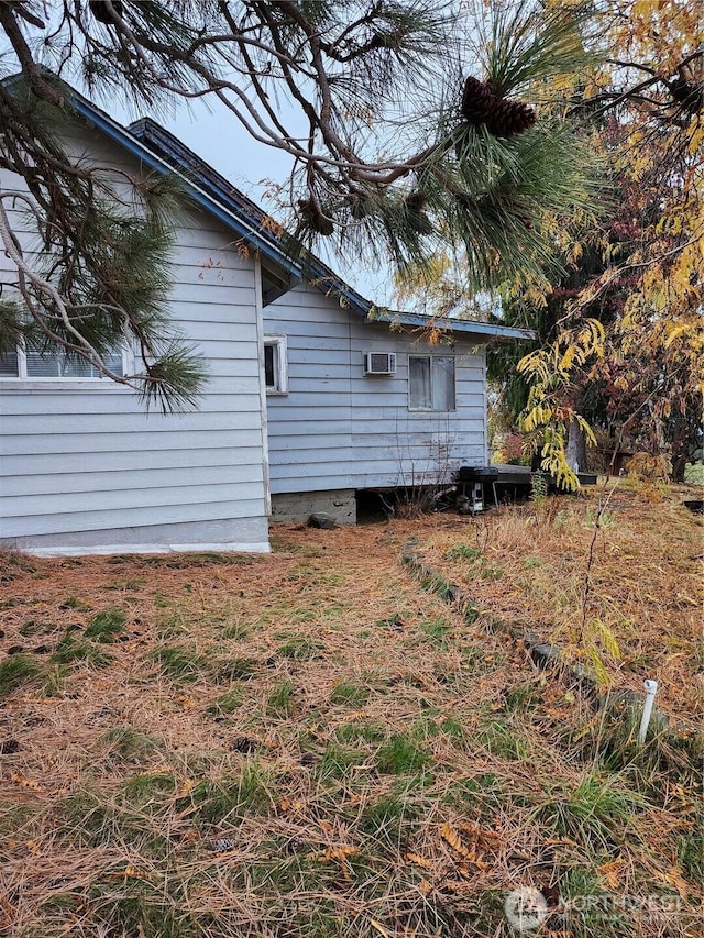 view of property exterior with a wall mounted AC