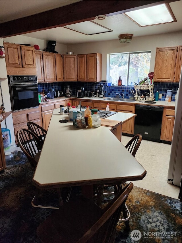 kitchen with a sink, brown cabinets, tasteful backsplash, and black appliances