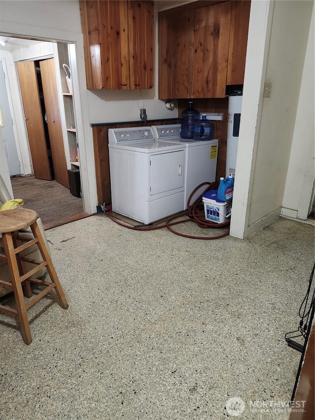 washroom featuring cabinet space, water heater, and washing machine and clothes dryer