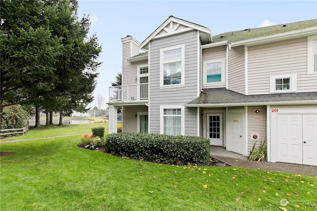 view of front of property featuring a balcony and a front lawn