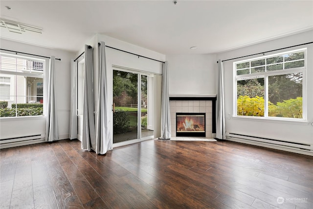 unfurnished living room featuring baseboard heating, a fireplace, and dark hardwood / wood-style floors