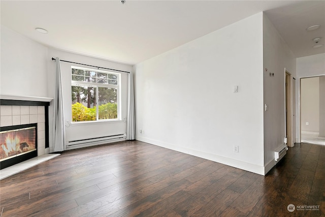 unfurnished living room with dark hardwood / wood-style floors, baseboard heating, and a tiled fireplace