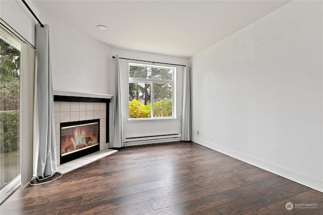 unfurnished living room featuring a wealth of natural light, a baseboard radiator, and wood-type flooring