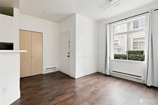 foyer entrance with baseboard heating and dark hardwood / wood-style floors