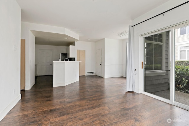 spare room with dark hardwood / wood-style flooring and a baseboard heating unit