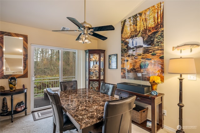 dining space with ceiling fan and light colored carpet