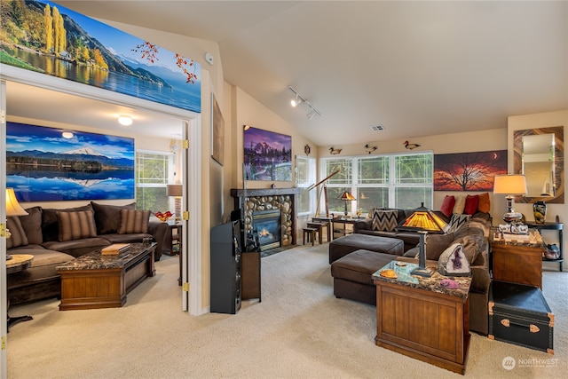 living room with rail lighting, light colored carpet, a fireplace, and vaulted ceiling