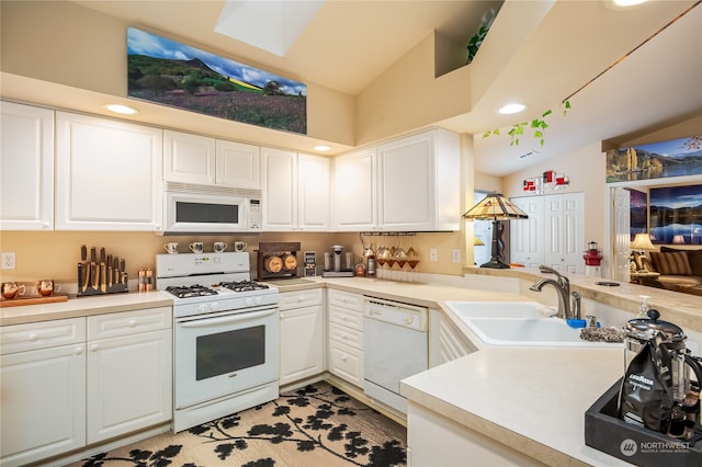 kitchen with vaulted ceiling, sink, white cabinets, and white appliances