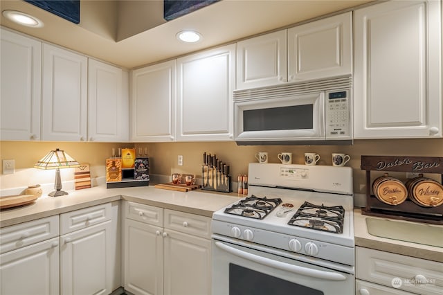 kitchen featuring white cabinets and white appliances