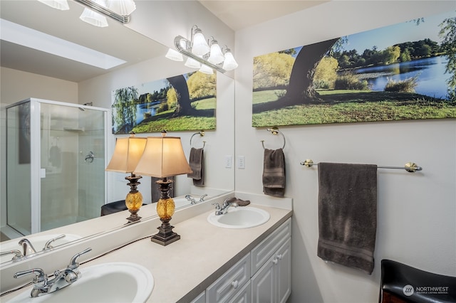 bathroom featuring a skylight, vanity, and an enclosed shower