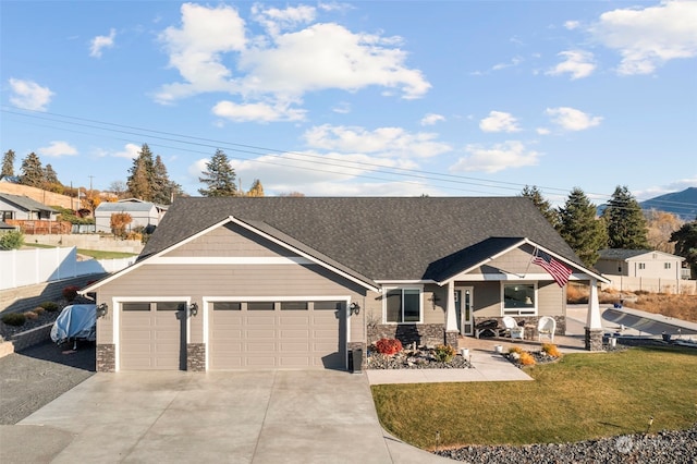 view of front of home with driveway, stone siding, a garage, and fence