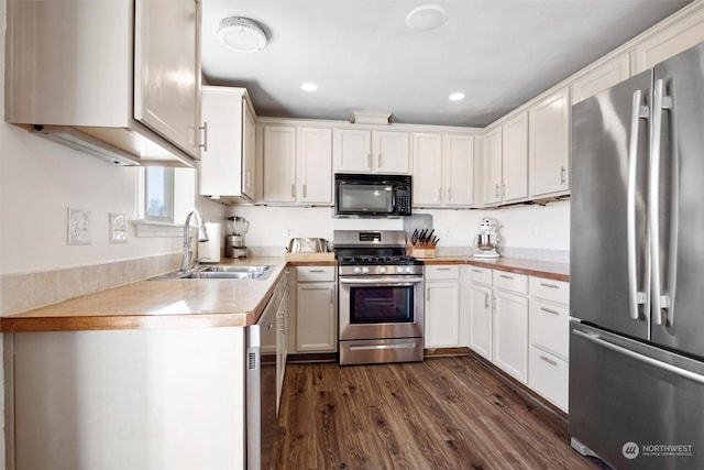 kitchen with white cabinetry, stainless steel appliances, dark wood-type flooring, and sink