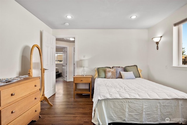 bedroom with dark hardwood / wood-style floors and multiple windows