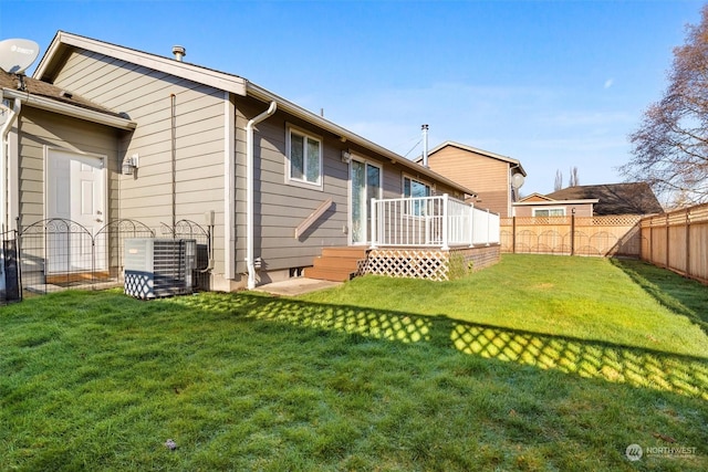 rear view of house with a lawn and central air condition unit