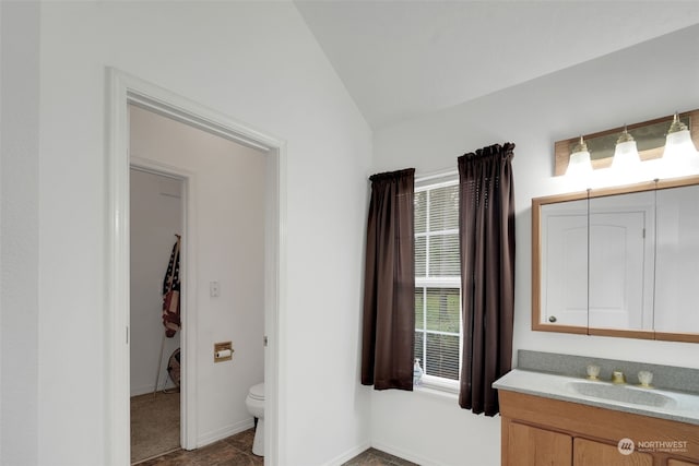 bathroom with vanity, toilet, and vaulted ceiling