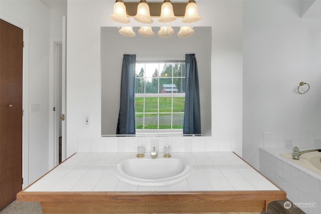 bathroom with a relaxing tiled tub and a chandelier