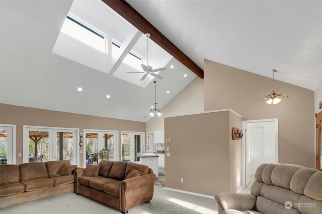 living room featuring light carpet, french doors, ceiling fan with notable chandelier, beam ceiling, and high vaulted ceiling