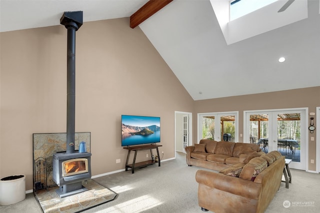 carpeted living room with french doors, ceiling fan, high vaulted ceiling, beamed ceiling, and a wood stove