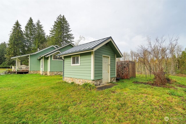 back of house with a yard and a storage unit