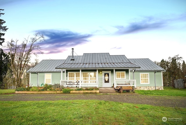 view of front of home featuring covered porch and a yard