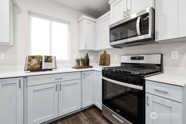 kitchen with dark hardwood / wood-style floors, white cabinetry, and stainless steel appliances