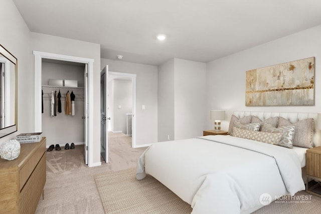 bedroom featuring a walk in closet, light carpet, and a closet