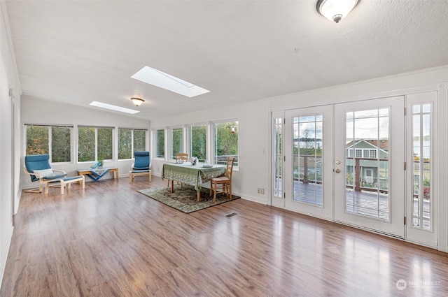 unfurnished sunroom with a healthy amount of sunlight, lofted ceiling with skylight, and french doors