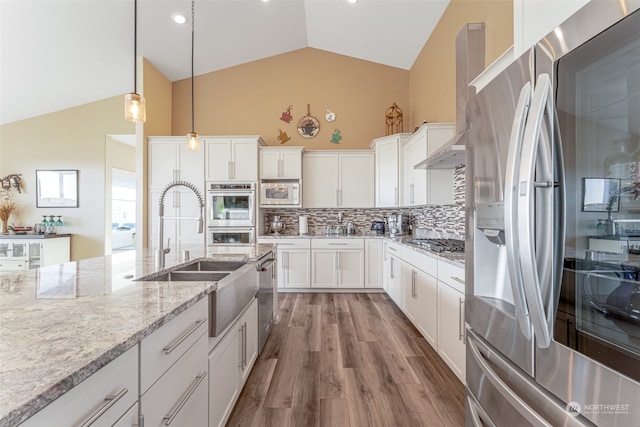 kitchen featuring white cabinets, hanging light fixtures, decorative backsplash, wood-type flooring, and stainless steel appliances