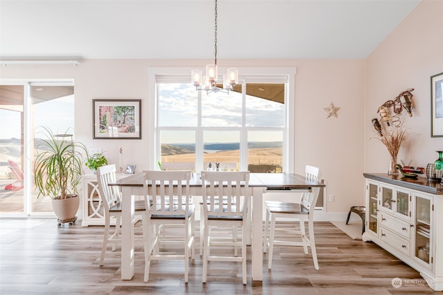 dining room featuring a notable chandelier, a mountain view, and light wood-type flooring