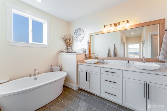 bathroom with a washtub and vanity