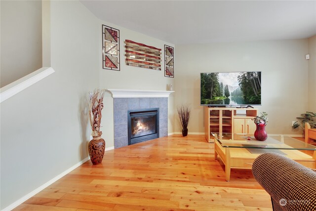 sitting room with wood-type flooring and a tiled fireplace