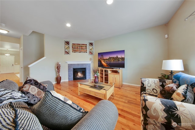 living room featuring hardwood / wood-style flooring and a tiled fireplace