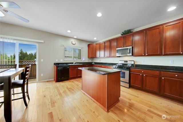 kitchen with sink, ceiling fan, a kitchen island, appliances with stainless steel finishes, and light hardwood / wood-style floors