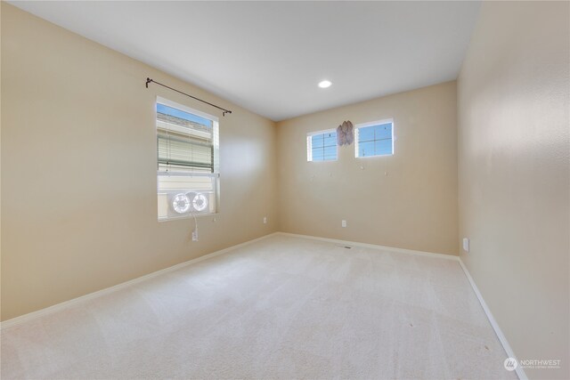 spare room featuring light colored carpet