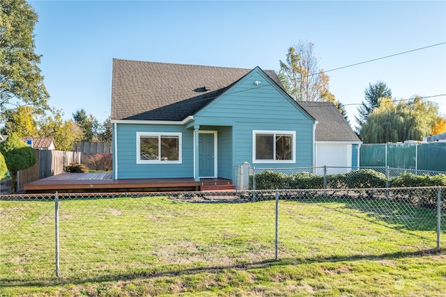 view of front of property featuring a front yard, a garage, and a wooden deck