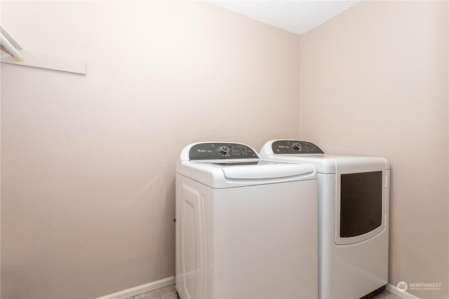 clothes washing area featuring washing machine and clothes dryer and a textured ceiling