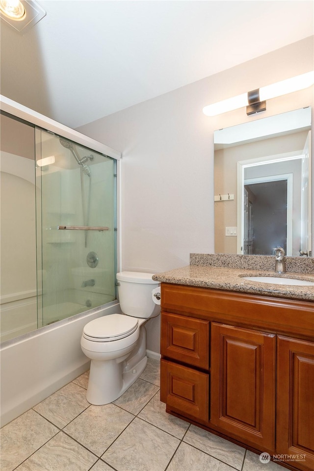 full bathroom with tile patterned floors, vanity, bath / shower combo with glass door, and toilet