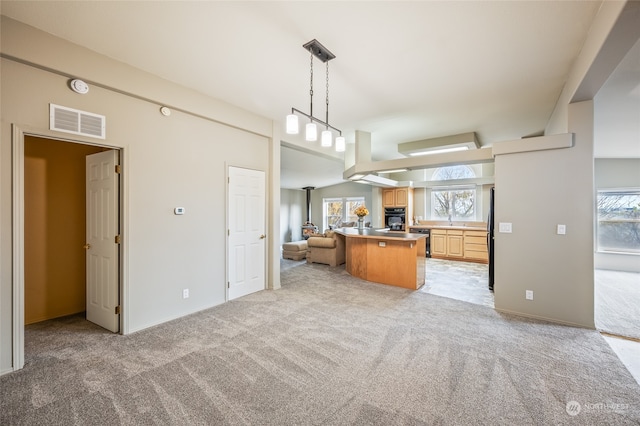 kitchen with light carpet, a kitchen bar, kitchen peninsula, sink, and oven