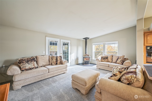 living room featuring carpet, lofted ceiling, and a wood stove