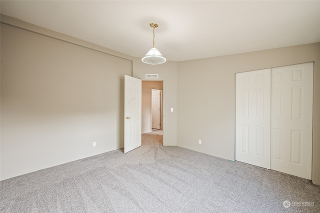 unfurnished bedroom with carpet flooring and a closet